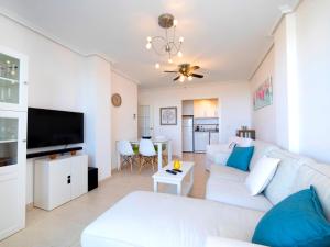 a living room with a white couch and a tv at Apartment Residencial Jazmines by Interhome in Calpe