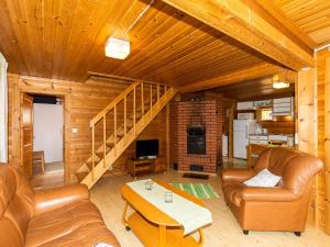 AsikkalaにあるHoliday Home Paapuuri by Interhomeのリビングルーム(革製家具、木製の天井付)