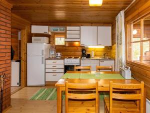 a kitchen with a table and chairs in a cabin at Holiday Home Paapuuri by Interhome in Asikkala