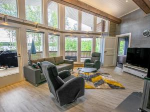 Il comprend un salon avec des canapés et une télévision à écran plat. dans l'établissement Holiday Home Nummentähti by Interhome, à Tammela