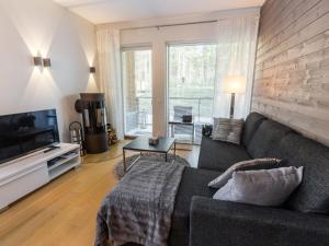 una sala de estar con un sofá y un televisor en Holiday Home Tunturinlaita b3 by Interhome, en Levi