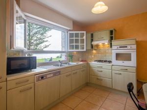 a kitchen with white cabinets and a window and a sink at Apartment Le Moulin by Interhome in Saint-Philibert +12 photos
