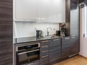una cocina con armarios de madera y un aparato de acero inoxidable en Holiday Home Tunturinlaita b3 by Interhome, en Levi 13 fotos más
