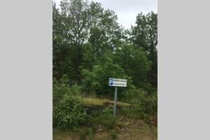 a sign in the middle of a field with trees at Family-Friendly Coastal Getaway Near Kragerø 3 in Kragerø