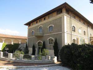 un grande edificio con una recinzione di fronte ad esso di Il Cantinone a San Vincenzo