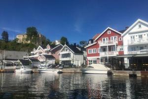 a group of houses next to the water with boats at Family-Friendly Coastal Getaway Near Kragerø 3 in Kragerø