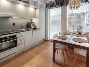 a kitchen with a table and a dining room at Holiday Home Tunturinlaita c1 by Interhome in Sirkka