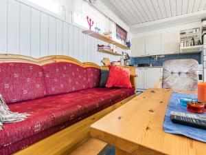 ein Wohnzimmer mit einem roten Sofa und einem Holztisch in der Unterkunft Holiday Home Kivirinne by Interhome in Äijälä