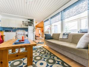 ein Wohnzimmer mit einem Sofa und einem Tisch in der Unterkunft Holiday Home Kivirinne by Interhome in Äijälä