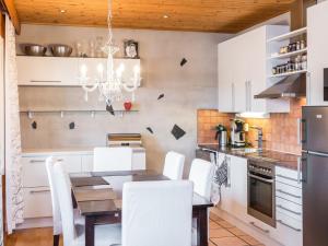 a kitchen with a dining table and white chairs at Holiday Home Tahkon rantatupa 7 b by Interhome in Tahkovuori
