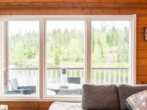 a living room with two large windows and a table at Holiday Home Tahkon rantatupa 7 b by Interhome in Tahkovuori