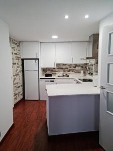 a kitchen with white cabinets and white appliances at Ca la Maria in La Seu d'Urgell