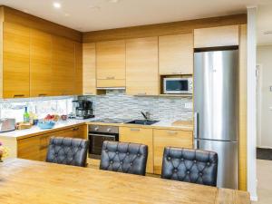 a kitchen with wooden cabinets and a stainless steel refrigerator at Holiday Home Ritari by Interhome in Pälkäne