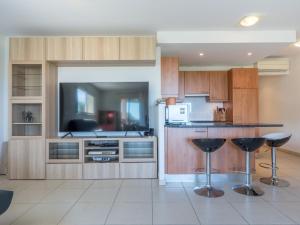 een keuken met houten kasten en een bar met krukken bij Apartment Presqu'île de la Lagune-3 by Interhome in Saint-Cyprien