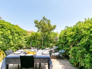 a table and chairs on a patio with bushes at Apartment Les Tulipes by Interhome in Carqueiranne