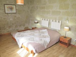 um quarto com uma cama com lençóis brancos e 2 candeeiros em Holiday Home Saint Martin by Interhome em Puymiclan