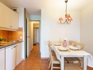 a kitchen and dining room with a white table and chairs at Apartment Les Terrasses d'Arcangues-4 by Interhome in Arcangues