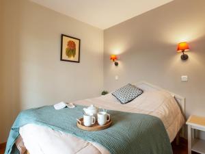 a bedroom with a bed with a tray with mugs on it at Apartment Les Terrasses d'Arcangues-4 by Interhome in Arcangues +12 photos