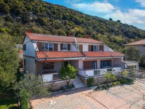 een huis met een berg op de achtergrond bij Apartment Katica-1 by Interhome in Rab