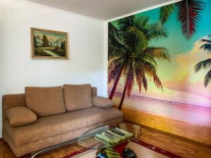 een woonkamer met een bank en een muurschildering van palmbomen bij Apartment Katica-1 by Interhome in Rab