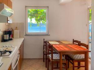 een keuken met een tafel en stoelen en een raam bij Apartment Katica-1 by Interhome in Rab +18 foto's