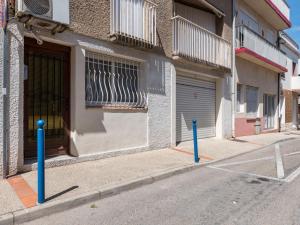 eine Straße mit zwei blauen Stangen vor einem Gebäude in der Unterkunft Studio Le Grec by Interhome in Le Grau-du-Roi