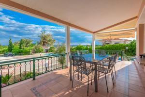 a patio with a table and chairs on a balcony at Villa Konstantinos in Alexandroupoli