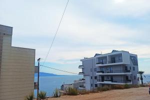 un edificio de apartamentos blanco al lado de una colina en Sweet Apartment en Sarandë