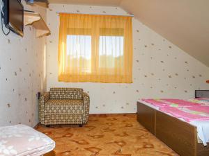 a bedroom with a bed and a window and a chair at Holiday Home Lampion by Interhome in Balatonmáriafürdő