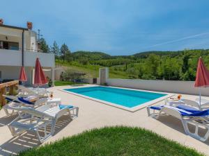 a villa with a swimming pool and patio furniture at Holiday Home Montebello by Interhome in Motovun