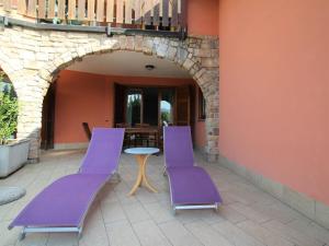 two purple chairs and a table on a patio at Apartment Residenza Agrifoglio-10 by Interhome in Luino