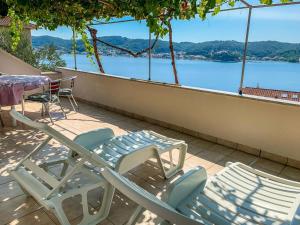- deux chaises et une table sur un balcon avec vue sur l'eau dans l'établissement Apartment Katica-2 by Interhome, à Rab