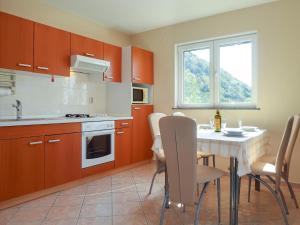 une cuisine avec une table et des chaises et une fenêtre dans l'établissement Apartment Katica-2 by Interhome, à Rab