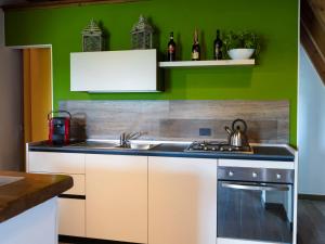 a kitchen with a sink and green walls at Chalet Melograno by Interhome in Sutri +23 photos