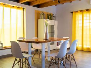 a dining room with a wooden table and white chairs at Chalet Melograno by Interhome in Sutri