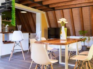 a dining room with a wooden table and white chairs at Chalet Melograno by Interhome in Sutri