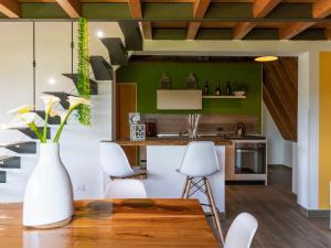 a kitchen with a wooden table and white chairs at Chalet Melograno by Interhome in Sutri