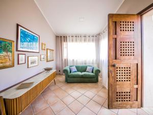 a living room with a green couch and a window at Apartment Bouganville di Patrizia by Interhome in Castellammare del Golfo