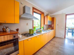 a kitchen with yellow cabinets and a stove at Villa La Vela by Interhome in Scopello