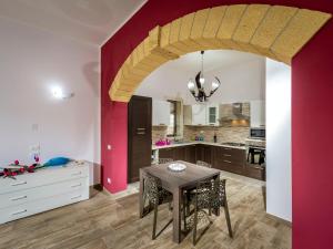 eine Küche mit einem Tisch und einer roten Wand in der Unterkunft Villa Mari e Monti by Interhome in Castellammare del Golfo