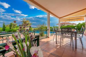 a patio with tables and chairs and a view of the ocean at Villa Konstantinos in Alexandroupoli