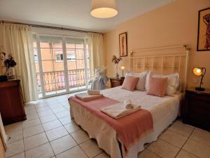 una camera da letto con un grande letto con asciugamani di El Desván Candeleda a Candeleda