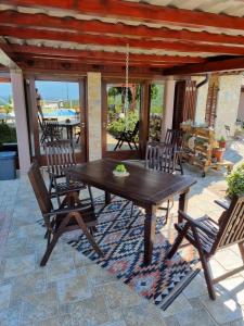 drewniany stół i krzesła na patio w obiekcie Casa Perla Holidays w mieście Juraši