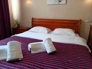 a bedroom with a bed with two towels on it at Apartments Deluxe in Ivano-Frankivsk