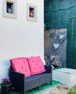 a chair with two pink cushions on a patio at Albergue-Hostel Casa da Gandara in Boimorto