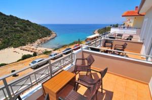 a balcony with chairs and a table and the ocean at Thalassorama Studios in Skala Marion