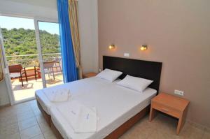 a bedroom with a large white bed and a balcony at Thalassorama Studios in Skala Marion +31 photos