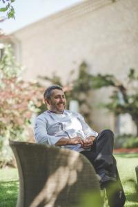 mężczyzna siedzący na ławce w trawie w obiekcie Mas de Boudan w mieście Nîmes