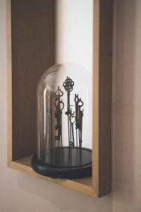 un groupe de clés dans un dôme de verre sur une étagère dans l'établissement Mas de Boudan, à Nîmes