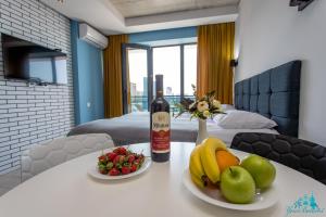 a bottle of wine sitting on a table with fruit at Your Beach Tower in Batumi +13 photos